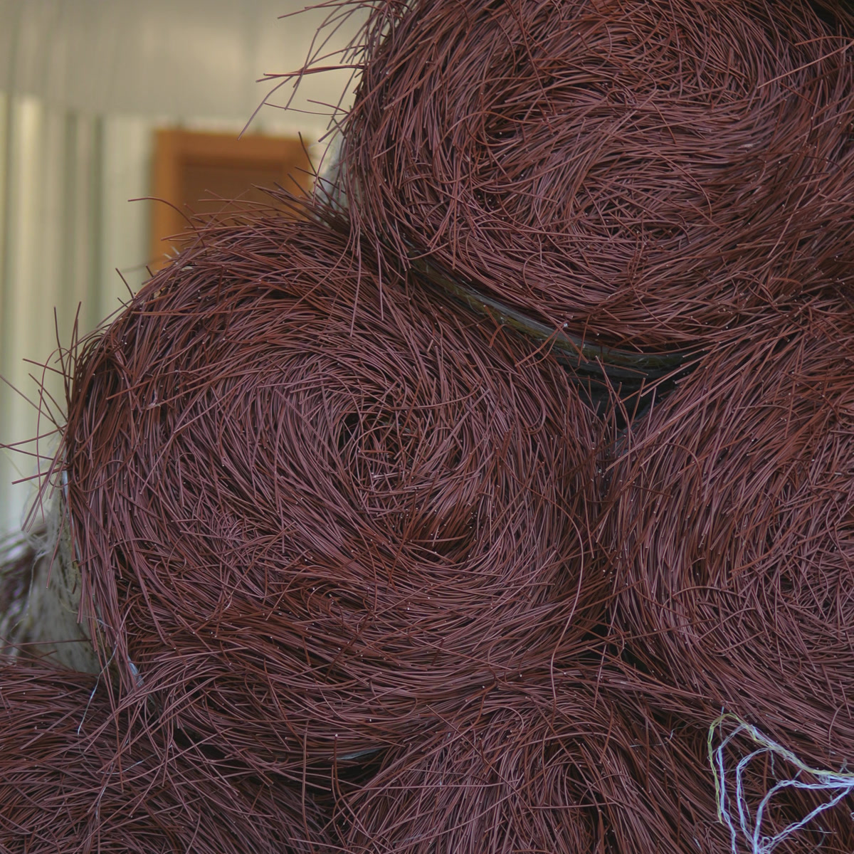 Synthetic pine straw rolls stacked, close view
